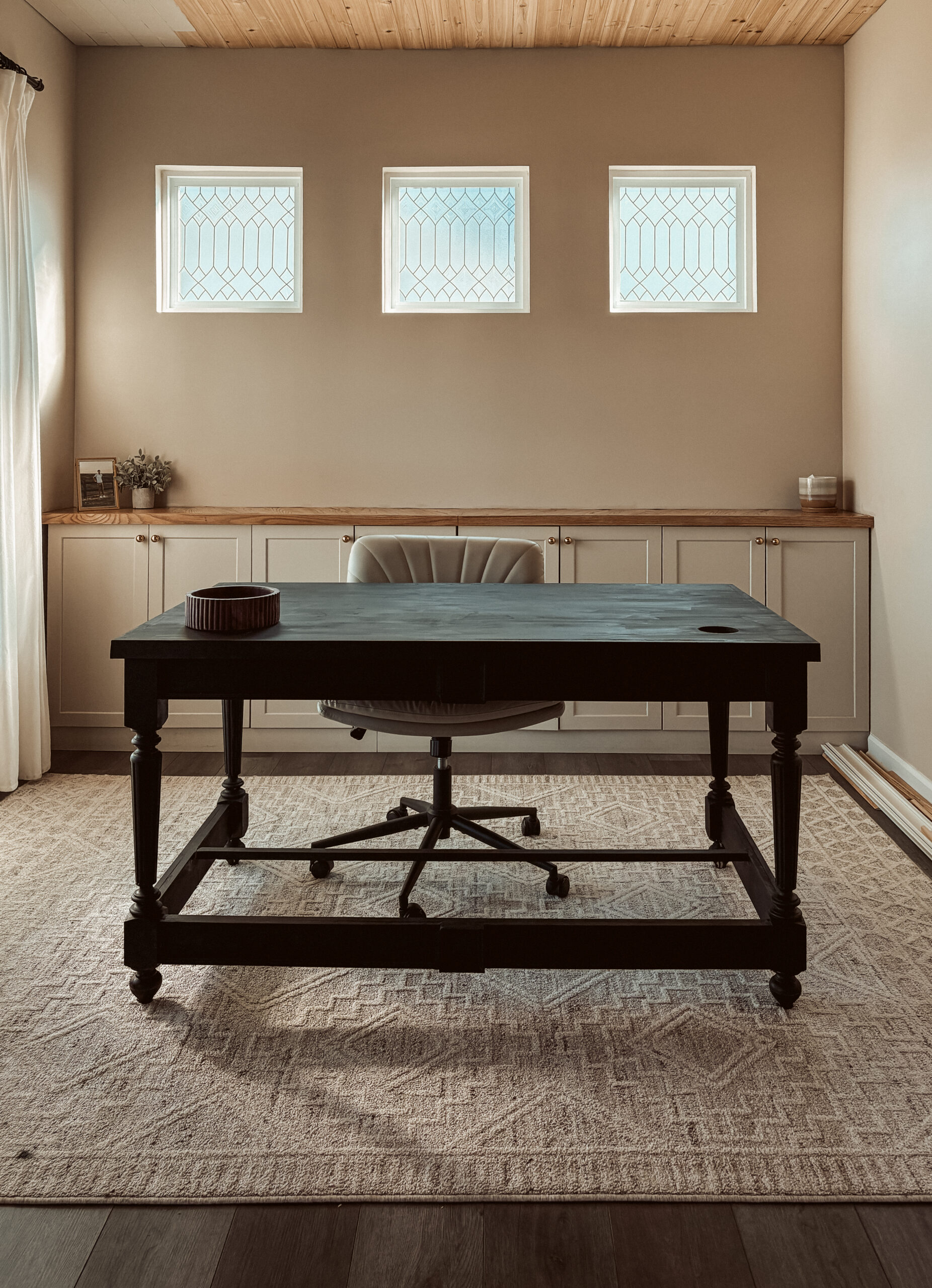 Desk in office space with cabinets in the back
